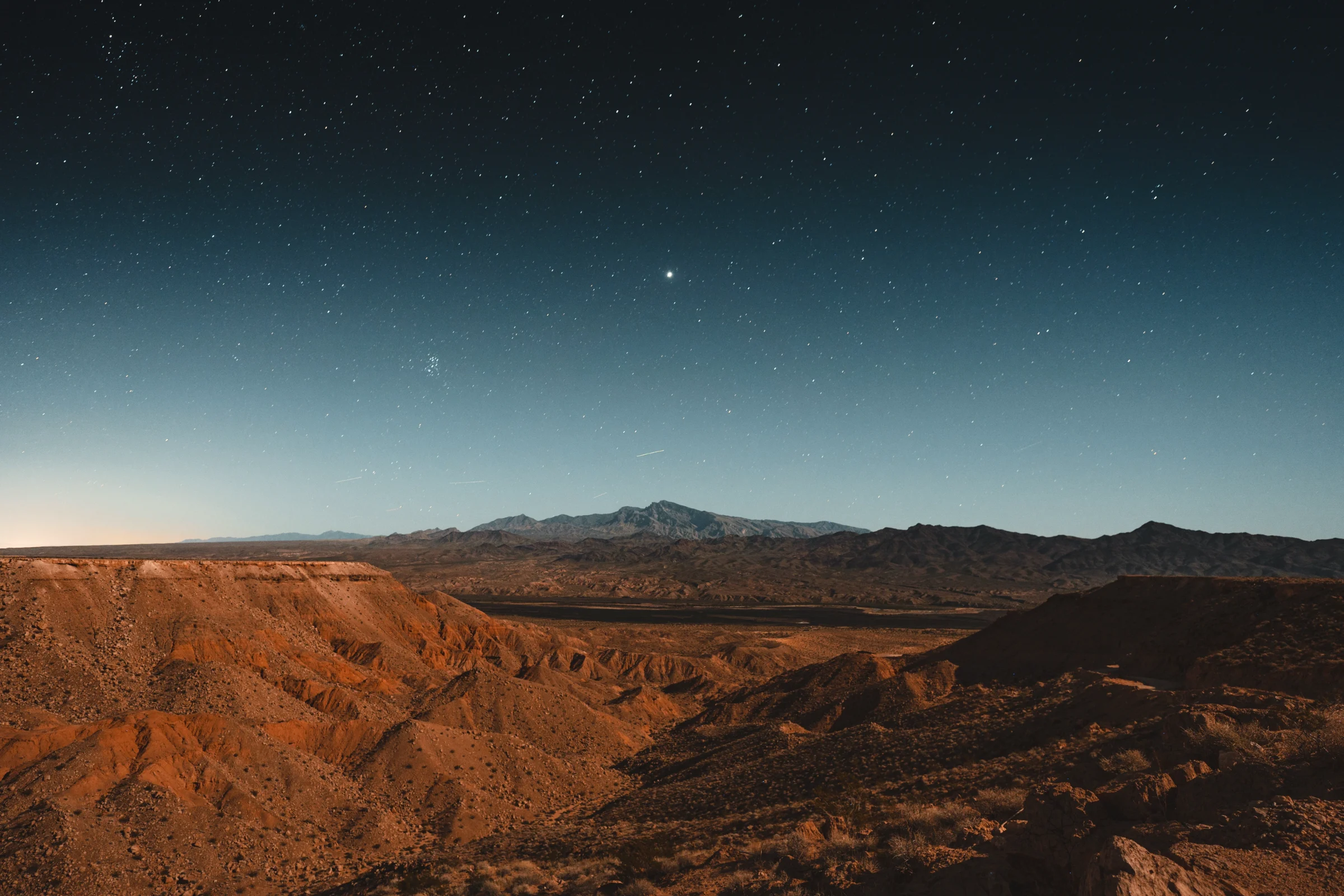 Nevada desert ridges under a deep starry night sky